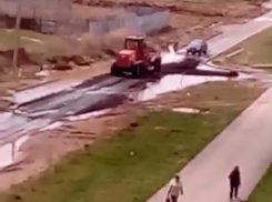Новый асфальт в Волжском рабочие укладывают прямо в лужу