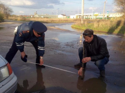 Водители замерили метровую выбоину напротив подразделения ГИБДД в Волжском