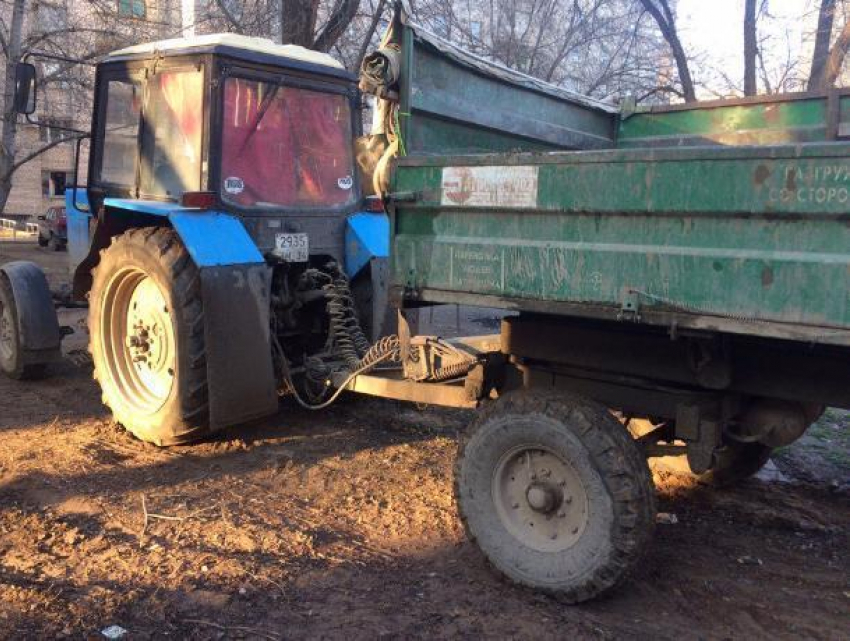 Управляющая компания паркует свой трактор во дворе жилого дома в Волжском