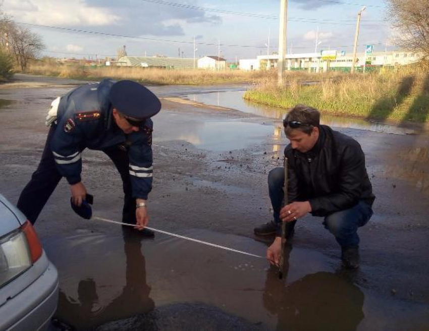 Водители замерили метровую выбоину напротив подразделения ГИБДД в Волжском